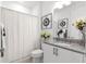 Bright bathroom features granite countertop, white cabinets, decorative accents, and shower with curtain at 8111 Sw 95Th Ct, Ocala, FL 34481