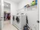 Well-lit laundry room complete with washer, dryer, shelving and convenient access to the walk in closet at 8111 Sw 95Th Ct, Ocala, FL 34481