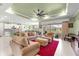 Open-concept living room with a ceiling fan, offering seamless access to the kitchen, dining area, and lanai at 8111 Sw 95Th Ct, Ocala, FL 34481
