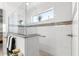 Bright bathroom shower featuring white tile, a glass partition, a window, and granite countertops at 8111 Sw 95Th Ct, Ocala, FL 34481