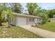 Well-maintained single-story home featuring an attached garage and green front lawn at 8449 Sw 105Th Pl, Ocala, FL 34481