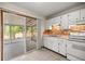 Bright kitchen featuring white cabinets, a brick backsplash, and a sliding door leading to an outdoor space at 8449 Sw 105Th Pl, Ocala, FL 34481