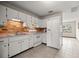 Functional kitchen featuring white cabinets, a brick backsplash, and essential appliances for everyday cooking at 8449 Sw 105Th Pl, Ocala, FL 34481