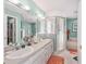 Bathroom with double sinks, a large mirror, vanity lighting, and a glass-enclosed shower at 8722 Sw 60Th Cir, Ocala, FL 34476