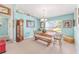 The dining room features neutral carpet, blue walls, a wooden table and bench near the bright window at 8722 Sw 60Th Cir, Ocala, FL 34476