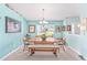 Dining room features blue walls, carpet and table with chairs and bench seating near large window at 8722 Sw 60Th Cir, Ocala, FL 34476