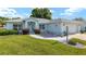 Charming single-story home featuring a well-manicured lawn and light blue exterior at 8722 Sw 60Th Cir, Ocala, FL 34476