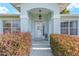 Inviting front entryway with a decorative door, sidelights, and manicured landscaping at 8722 Sw 60Th Cir, Ocala, FL 34476