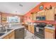 The kitchen features tile floors, light wood cabinets, black appliances, and a breakfast bar at 8722 Sw 60Th Cir, Ocala, FL 34476