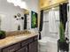 Bathroom featuring granite countertops, black accents, and shower-tub combination at 907 Trifu Ter, The Villages, FL 32163