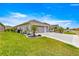 Well-maintained home with a lush green lawn, beautiful landscaping, and a wide driveway leading to a two-car garage at 907 Trifu Ter, The Villages, FL 32163
