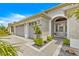 Close-up of the front entrance with well-kept landscaping, stylish exterior finishes, and a two-car garage at 907 Trifu Ter, The Villages, FL 32163