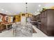 Open kitchen with granite island, stainless appliances, pendant lights, and tiled flooring at 907 Trifu Ter, The Villages, FL 32163