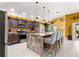 Island kitchen with granite countertops, stainless appliances, and eat-in bar area at 907 Trifu Ter, The Villages, FL 32163