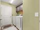 This laundry room is equipped with sleek white appliances, storage, and a contrasting trim, creating a clean functional space at 907 Trifu Ter, The Villages, FL 32163