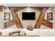 Unique accent wall featuring stone and wood, with a modern glass coffee table at 907 Trifu Ter, The Villages, FL 32163