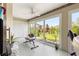 Bright sunroom with large windows, exercise equipment, and scenic backyard views at 907 Trifu Ter, The Villages, FL 32163