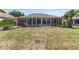 Large backyard with a patio, landscaping, green grass, and a glimpse of the screened-in porch at 9649 Sw 90Th St, Ocala, FL 34481