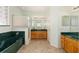 Bathroom with dual vanities, garden tub, tiled floors, and a step-in shower at 9649 Sw 90Th St, Ocala, FL 34481
