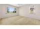 Bedroom with neutral walls and carpet, ceiling fan, and natural light streaming through several large windows at 9649 Sw 90Th St, Ocala, FL 34481