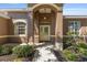 Inviting home entrance featuring a covered porch, decorative glass door, and a lush garden at 9649 Sw 90Th St, Ocala, FL 34481