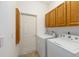 Functional laundry room featuring washer, dryer, and overhead cabinetry at 9649 Sw 90Th St, Ocala, FL 34481