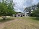 Rear exterior view of a single-story home with a chimney and ample backyard space at 9850 Sw 191St Ave, Dunnellon, FL 34432