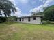 Side exterior view of a single-story home showcasing a well-maintained green lawn and lush landscaping at 9850 Sw 191St Ave, Dunnellon, FL 34432