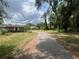 View of the long driveway leading to the house, surrounded by lush greenery and mature trees at 9850 Sw 191St Ave, Dunnellon, FL 34432