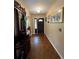 Well-lit entryway featuring a dark wood door, parquet floors, and a vintage cabinet with mirror at 9850 Sw 191St Ave, Dunnellon, FL 34432