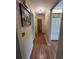 Hallway with wood flooring and neutral paint, leading to the kitchen and other rooms at 9850 Sw 191St Ave, Dunnellon, FL 34432
