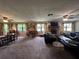 Spacious living room with a stone fireplace, large windows, and plush seating at 9850 Sw 191St Ave, Dunnellon, FL 34432