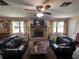A living room features couches, a fireplace, and large windows at 9850 Sw 191St Ave, Dunnellon, FL 34432