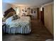 Spacious main bedroom featuring wood floors, a large bed, and a collection of decorative wall art at 9850 Sw 191St Ave, Dunnellon, FL 34432