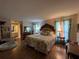 Comfortable main bedroom with hardwood floors, vintage decor, and bright windows at 9850 Sw 191St Ave, Dunnellon, FL 34432