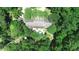 Aerial shot showcasing a secluded home embraced by a canopy of lush, mature trees and a sparkling pool at 1300 Sw 43Rd Pl, Ocala, FL 34471