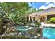 Beautiful backyard with a pool, waterfall, and covered patio, perfect for outdoor entertaining at 1300 Sw 43Rd Pl, Ocala, FL 34471