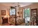 Comfortable bedroom with a four-poster bed, ceiling fan, sliding doors, and natural light at 1300 Sw 43Rd Pl, Ocala, FL 34471