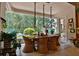 Bright dining area with wicker chairs, a wooden table, pendant lights, and views of the backyard pool at 1300 Sw 43Rd Pl, Ocala, FL 34471