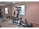Spacious exercise room with full mirrored wall, various weight machines, and natural light from a large window at 1300 Sw 43Rd Pl, Ocala, FL 34471