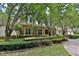 Well-maintained home featuring a brick facade, lush landscaping, and mature trees providing shade and privacy at 1300 Sw 43Rd Pl, Ocala, FL 34471