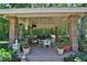 Covered outdoor kitchen area with a grill, dining table and chairs, and brick columns at 1300 Sw 43Rd Pl, Ocala, FL 34471