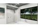 Stylish bathroom featuring a walk-in shower, modern tub, and large window offering natural light at 0000 Se 116Th Place Rd, Ocala, FL 34480