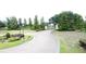 Gated community entrance featuring a winding driveway with mature landscaping at 0000 Se 116Th Place Rd, Ocala, FL 34480