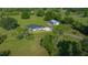 Scenic aerial view of a home with a large lawn, trees, and a separate storage building at 1058 Se 59Th St, Ocala, FL 34480