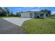 A charming exterior shows a large driveway and well-maintained landscaping surrounding the home at 1058 Se 59Th St, Ocala, FL 34480