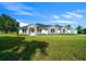 Charming home with stone accents, a manicured lawn, and verdant landscaping, all under a bright, sunny sky at 1058 Se 59Th St, Ocala, FL 34480