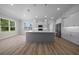 Bright kitchen with stainless steel appliances, white cabinets, large island, and wood flooring at 1058 Se 59Th St, Ocala, FL 34480