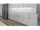 Modern kitchen featuring white cabinets, stainless refrigerator, quartz countertops, and hardwood floors at 1058 Se 59Th St, Ocala, FL 34480