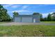Exterior features a large metal outbuilding with two roll up doors at 1058 Se 59Th St, Ocala, FL 34480